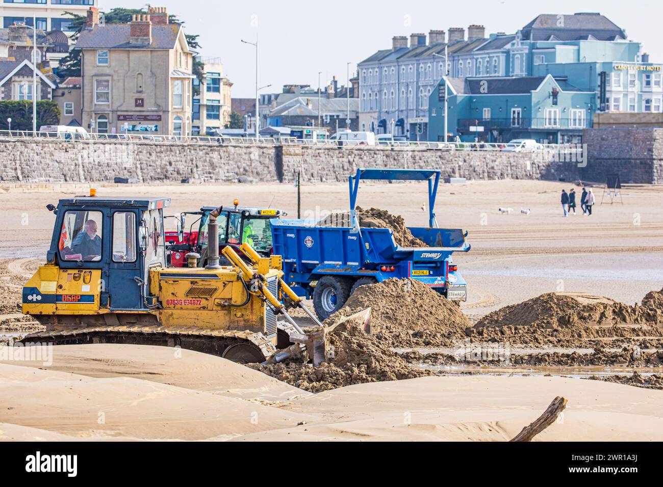 Bulldozer moving sand on Weston Super Mare Beach to combat the effect of long shore drift before the summer season Stock Photo