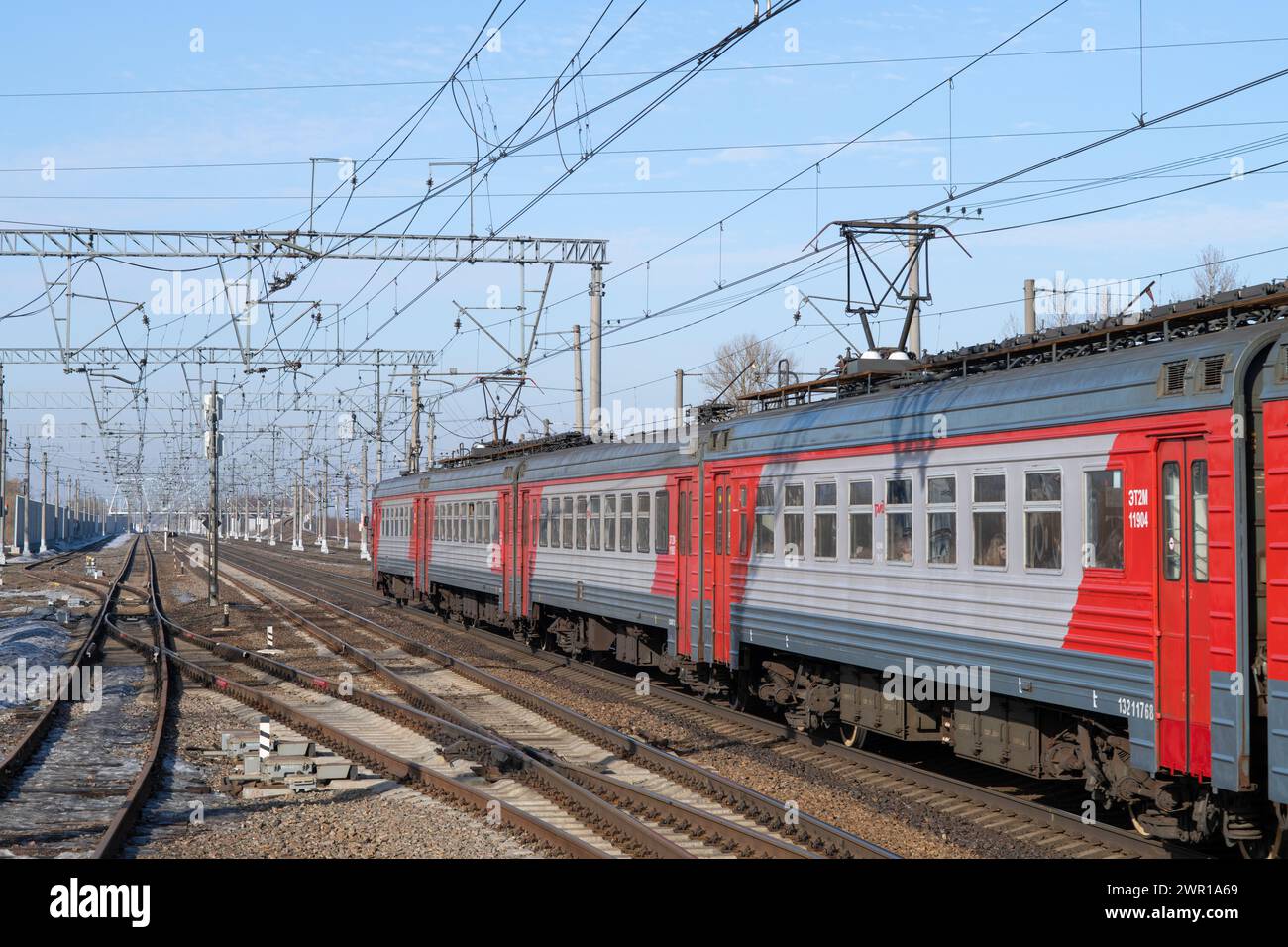 SLAVYANKA, RUSSIA - MARCH 04, 2024: Suburban electric train ET2M departs from the station on a sunny March day. Oktyabrskaya Railway Stock Photo