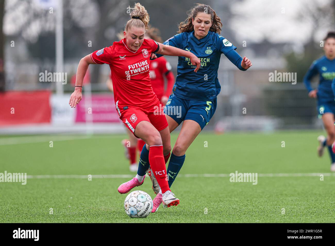 Enschede, Netherlands. 10th Mar, 2024. ENSCHEDE, NETHERLANDS - MARCH 10: Danique van Ginkel of FC Twente, Melanie Bross of PSV battle for the ball during the Dutch Azerion Vrouwen Eredivisie match between FC Twente and PSV at Schreurserve on March 10, 2024 in Enschede, Netherlands. (Photo by Ben Gal/Orange Pictures) Credit: Orange Pics BV/Alamy Live News Stock Photo