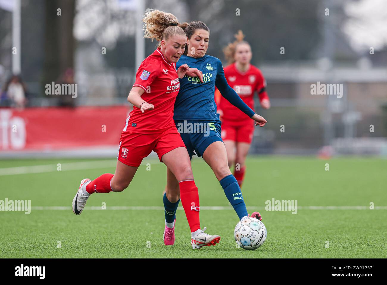 Enschede, Netherlands. 10th Mar, 2024. ENSCHEDE, NETHERLANDS - MARCH 10: Danique van Ginkel of FC Twente, Melanie Bross of PSV battle for the ball during the Dutch Azerion Vrouwen Eredivisie match between FC Twente and PSV at Schreurserve on March 10, 2024 in Enschede, Netherlands. (Photo by Ben Gal/Orange Pictures) Credit: Orange Pics BV/Alamy Live News Stock Photo