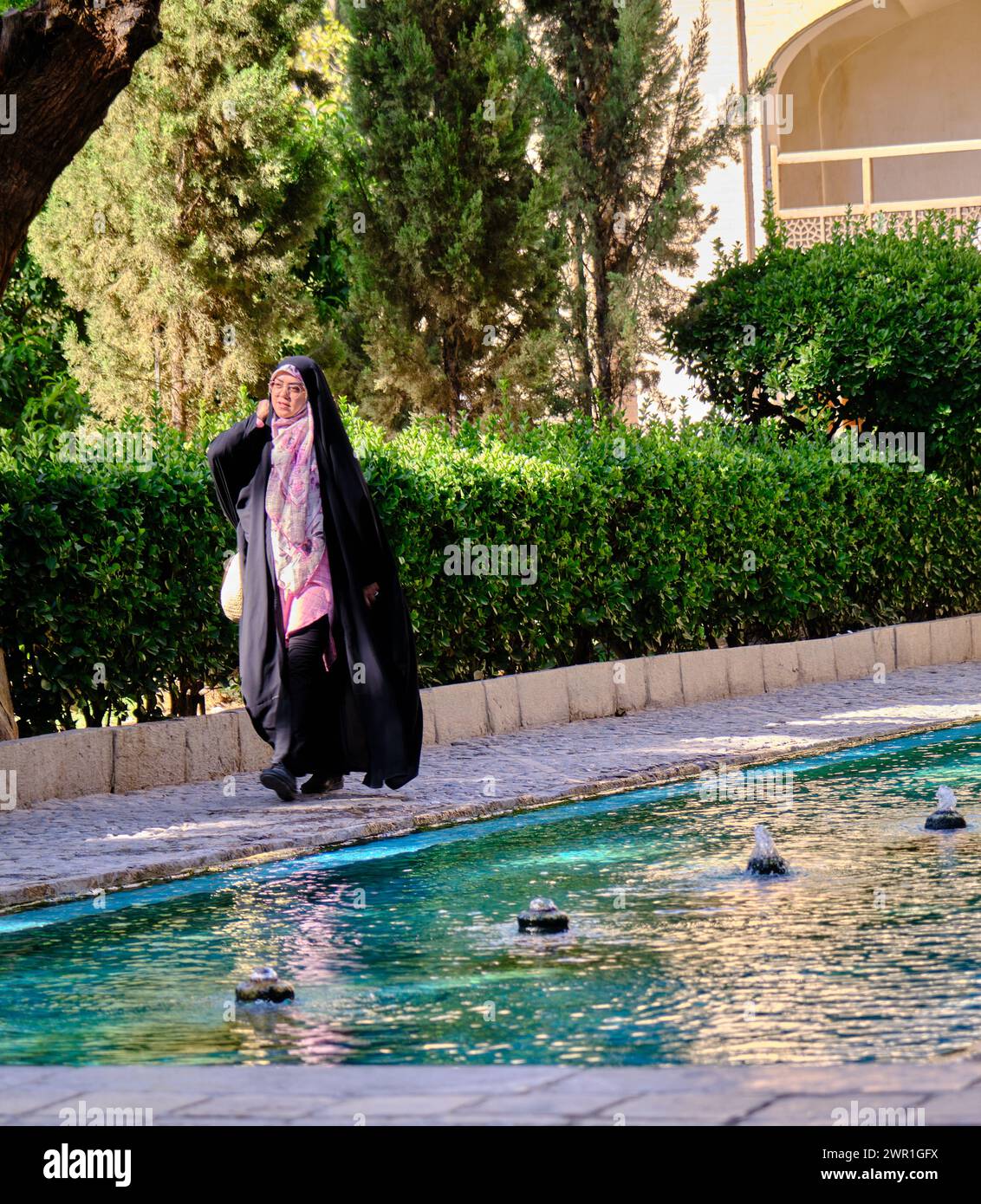 Kashan, Iran, 07.01.2023: Fin Garden in Kashan, iran, a woman wearing hijab and black burka dress Stock Photo
