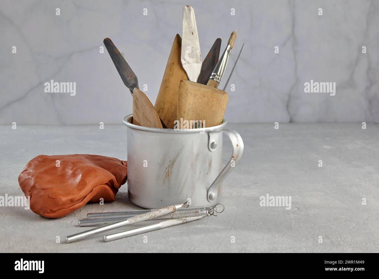 Various sculpting tools for modeling and pieces of clay and plasticine on a light background of an art workshop Stock Photo