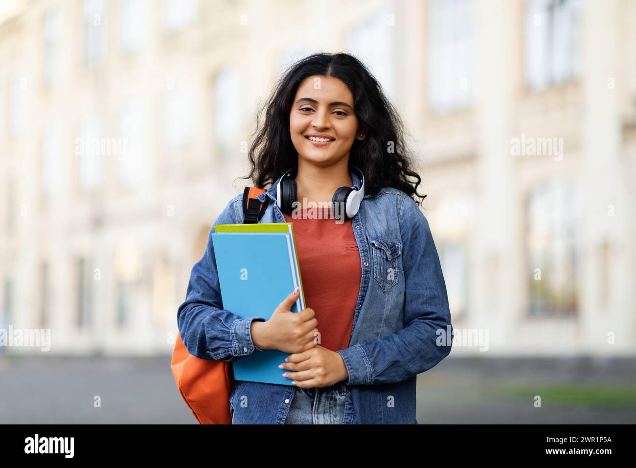 Positive middle eastern lady student posing at university campus Stock Photo