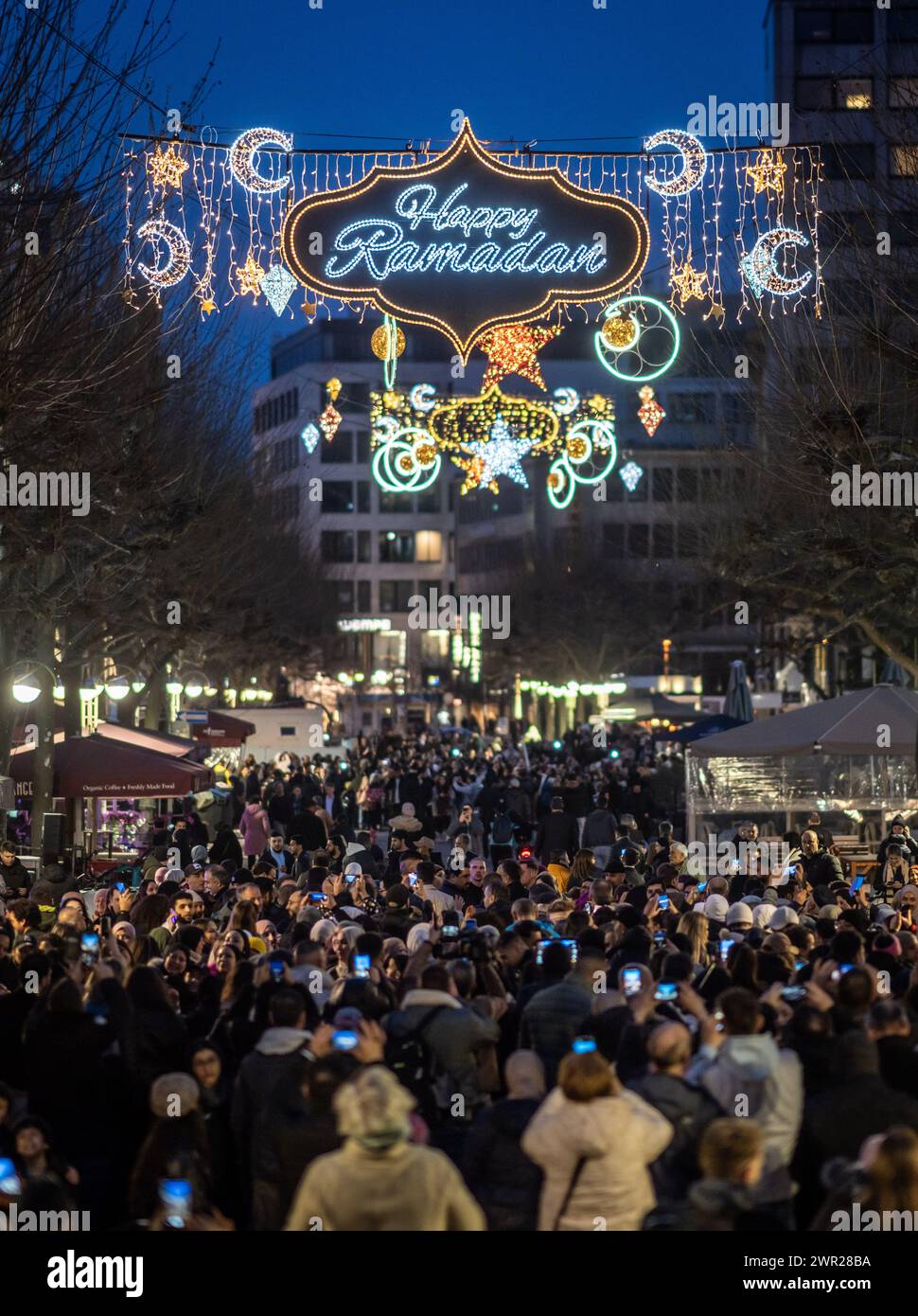 10 March 2024, Hesse, Frankfurt/Main: Stars, moons and the words 'Happy Ramadan' light up Frankfurt's Fressgass at nightfall. The illumination is considered unique in Germany and is aimed at Muslims who are currently observing the fasting month of Ramadan. Photo: Frank Rumpenhorst/dpa Stock Photo