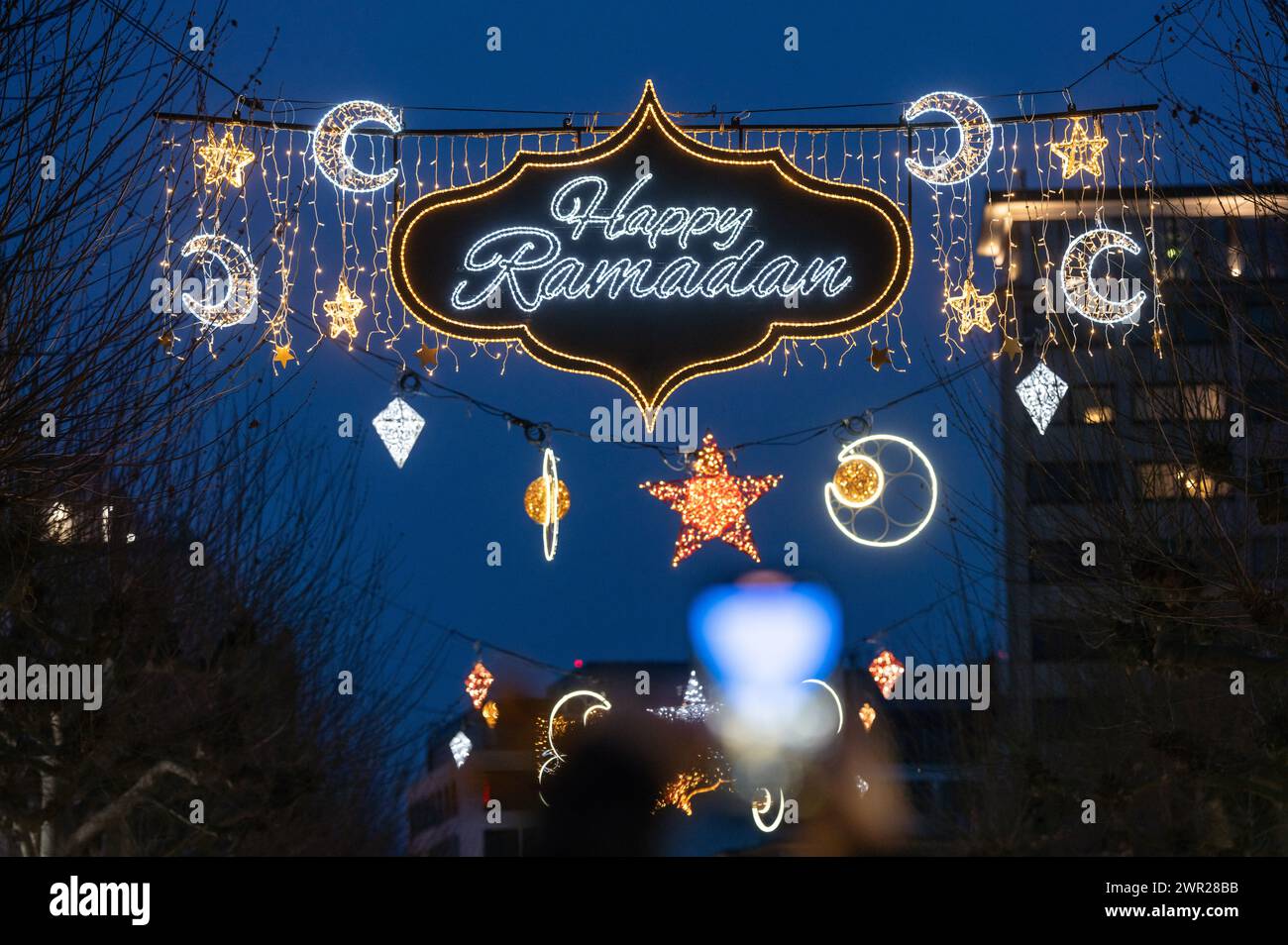 10 March 2024, Hesse, Frankfurt/Main: Stars, moons and the words 'Happy Ramadan' light up Frankfurt's Fressgass at nightfall. The illumination is considered unique in Germany and is aimed at Muslims who are currently observing the fasting month of Ramadan. Photo: Frank Rumpenhorst/dpa Stock Photo