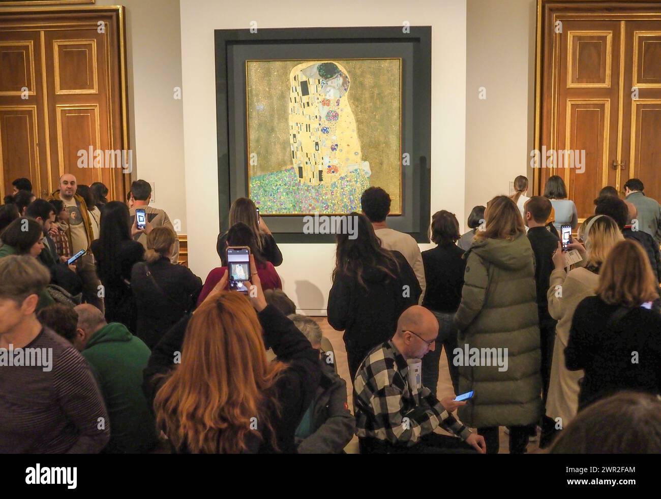 Visitors view paintings of Gustav Klimt, Kiss, 1908/1909. Belvedere museum located in palace owned by Imperial family of Austrian empire. Now in the building of Upper Belvedere there is famous art museum. Stock Photo