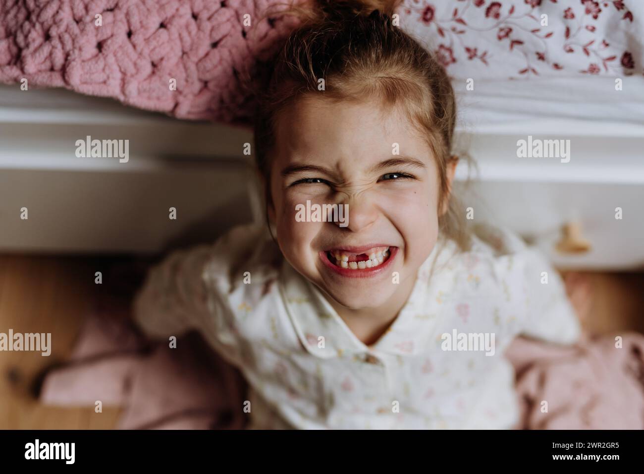 Portrait of cute girl smiling with gap-toothed grin, missing her baby teeth. Stock Photo