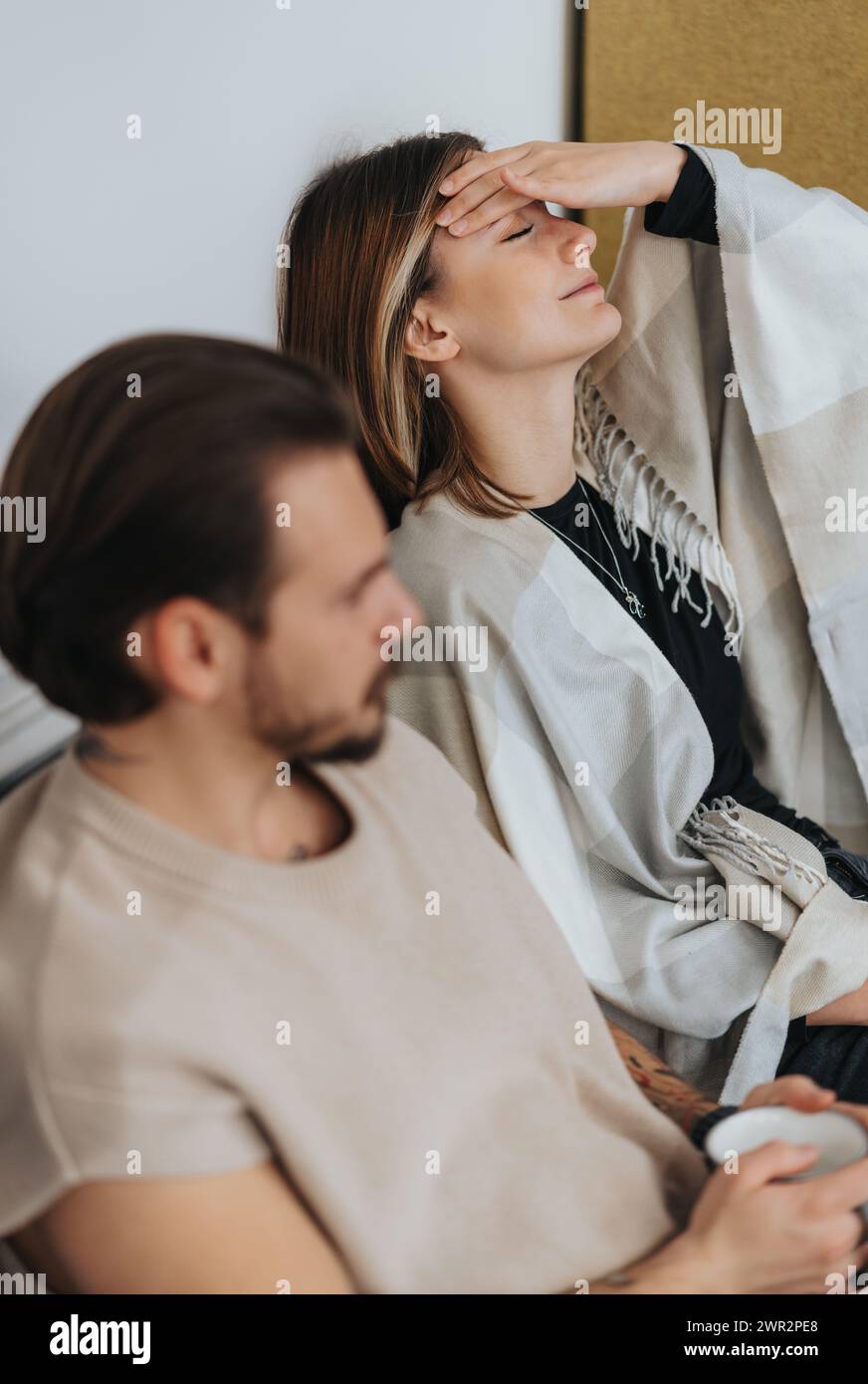 Two colleagues taking a break. Woman massaging her eyes and forehead while resting from work. Stock Photo