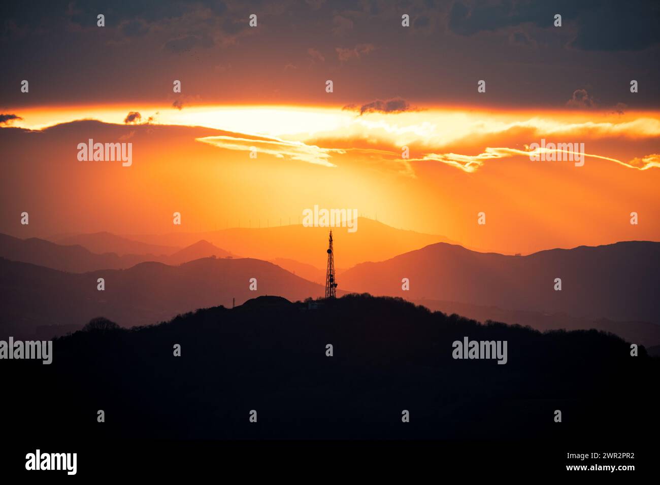 landscape of a sunset in the mountains, images with a lot of contrast and a large orange and reddish sky typical of the golden hour, in the center of Stock Photo