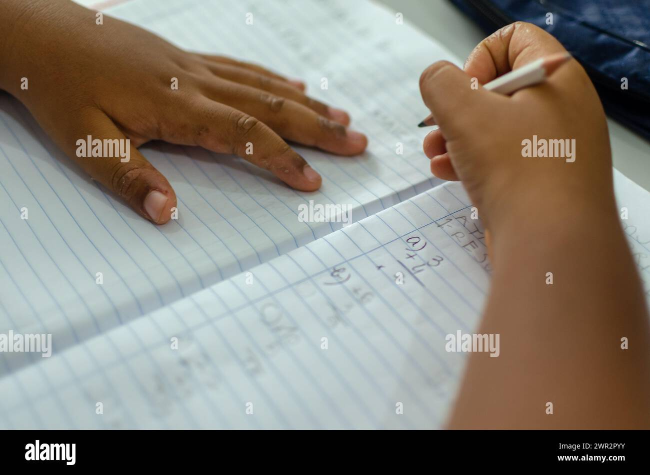 Salvador, Bahia, Brazil - April 19, 2016: Close-up portrait of the hands of a public school student writing in a notebook. City of Salvador, Bahia. Stock Photo