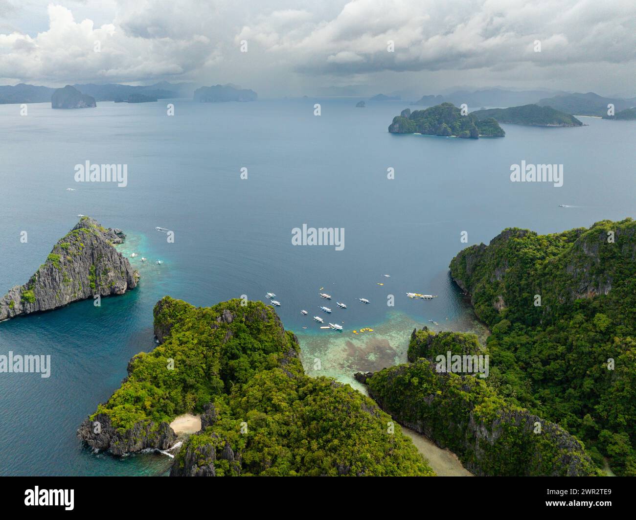 Boats and Kayaks over the blue sea. Miniloc and Twin Rocks in El Nido ...
