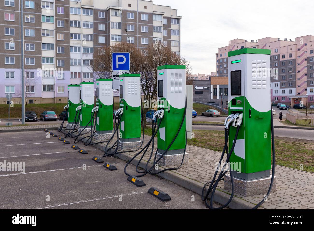 Car parking with charging stations near a multistorey apartment building. Green energy