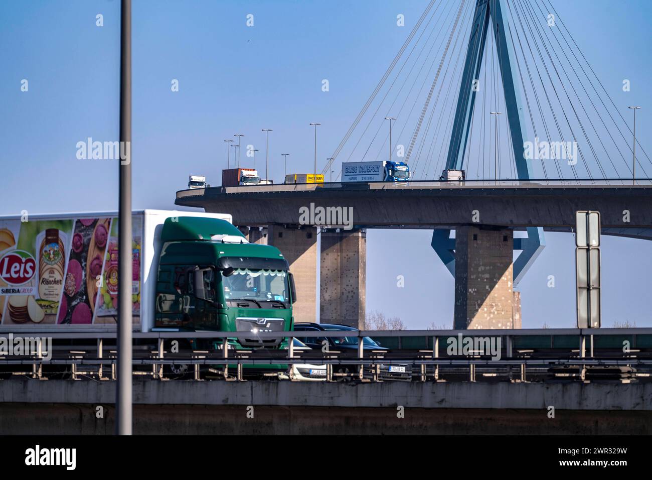 Die Köhlbrandbrücke im Hamburger Hafen, vorne Verkehr auf der Autobahn A7, überspannt den 325 m breiten Köhlbrand, einen Arm der Süderelbe, der Brückenzug ist über 3600 Meter lang, 53 Meter über dem Wasser, Pfeiler 135 m hoch, mehr als 30.000 Fahrzeuge, befahren die B3 Brücke täglich, wichtige Verbindung in den Hafen, sie ist marode, soll neu gebaut werden, Hamburg, Deutschland Kühlbrandbrücke *** The Köhlbrand Bridge in the port of Hamburg, in front traffic on the A7 freeway, spans the 325 m wide Köhlbrand, an arm of the Süderelbe, the bridge is over 3600 meters long, 53 meters above the wate Stock Photo