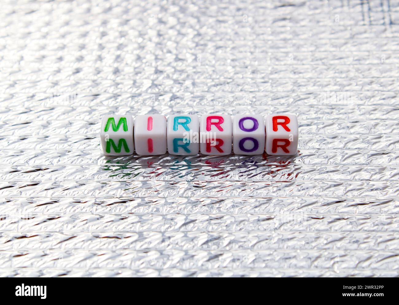 Mirror word composed with cubes on silver background Stock Photo