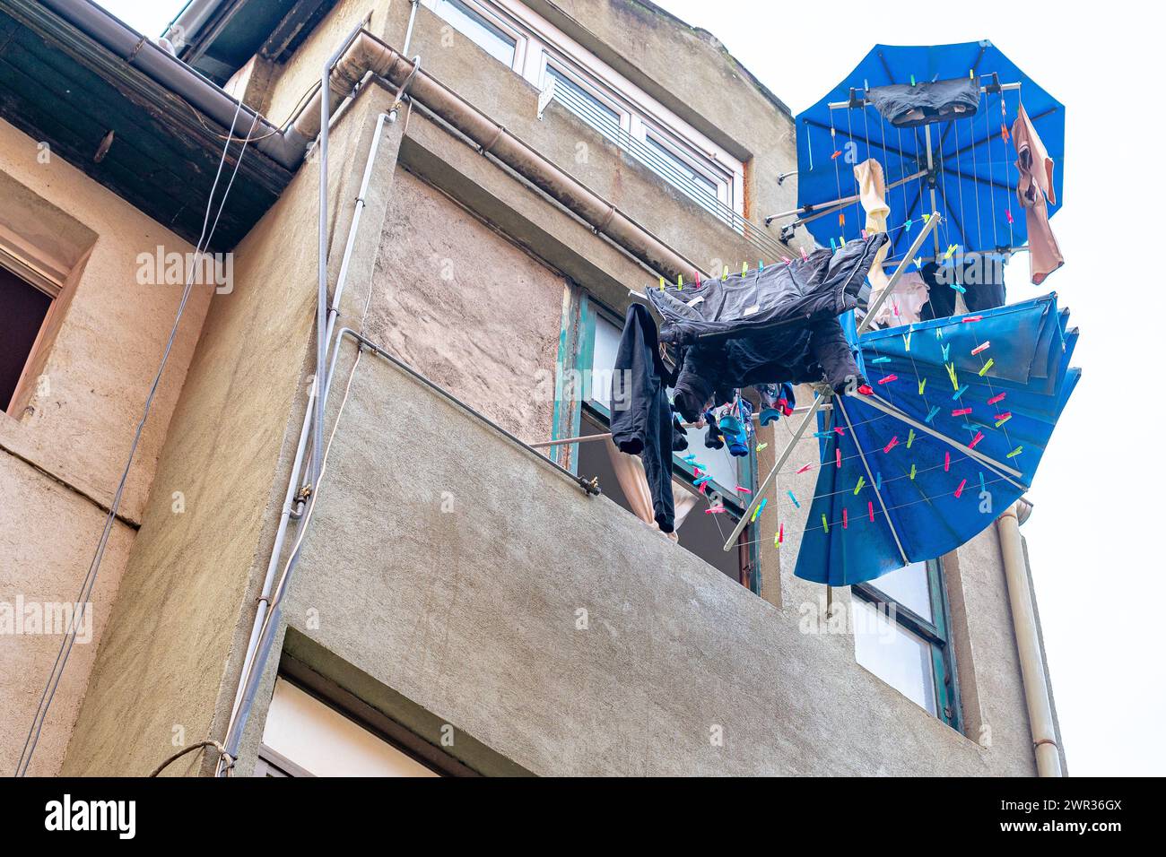 Clothes drying rack in the shape of an umbrella in use on the facade of a residential building in Bilbao. Stock Photo