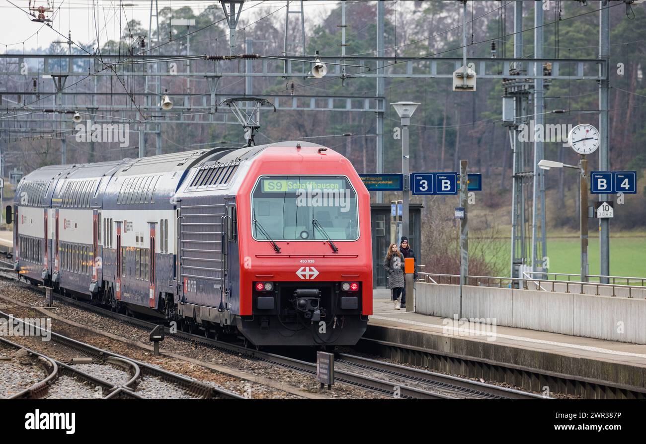 Eine Zürcher S-Bahn der Linie S9 lässt beim Bahnhof Hüntwangen Fahrgäste ein- und aussteigen. Die Linie verkehrt von Schaffhausen über den Zürcher HB Stock Photo