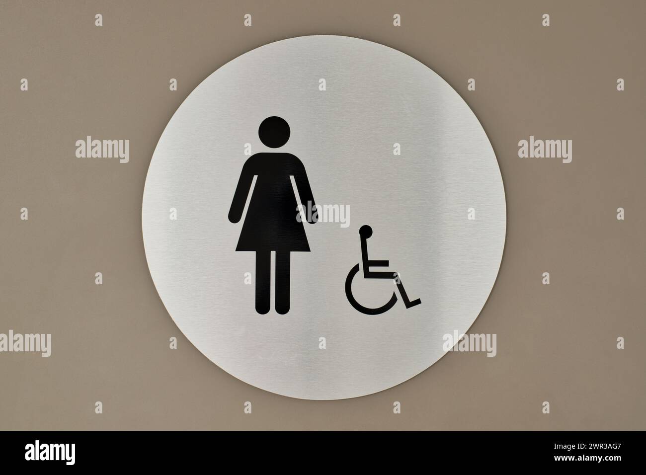 Women's bathroom and handicap sign on a door. Circular sign and symbol designation placard. Stock Photo