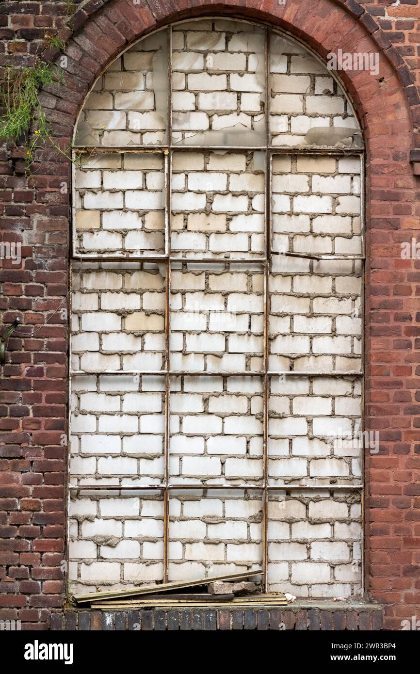 Arched window walled up with visible decay and texture Stock Photo - Alamy
