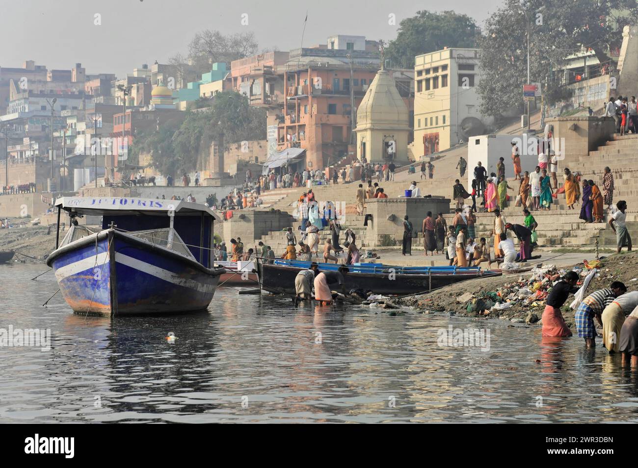 Boat on the riverbank with city view and people in everyday life, Varanasi, Uttar Pradesh, India Stock Photo