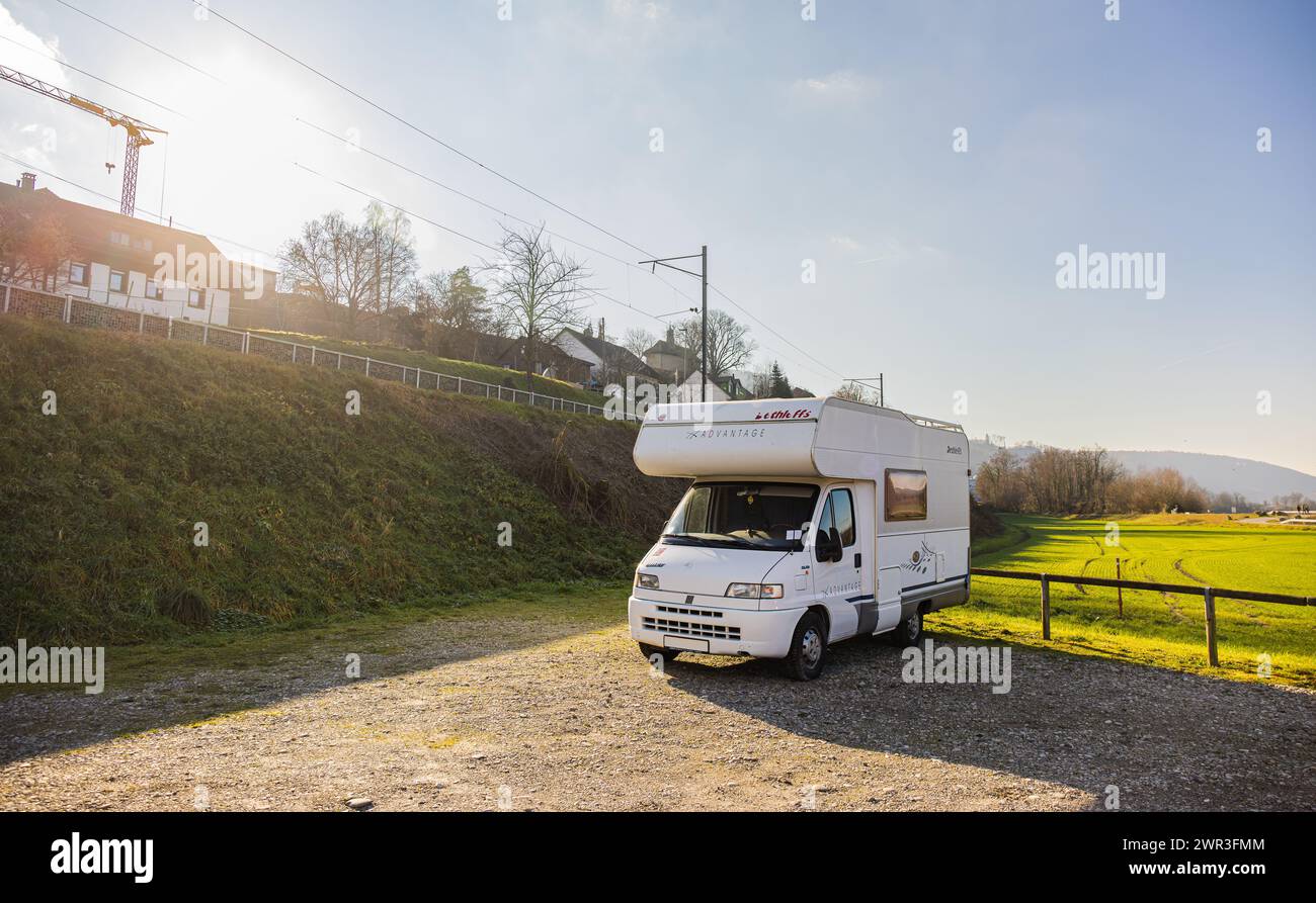 Auf einem unmarkierten Kiesparkplatz steht ein verlassenes Wohnmobil der Marke Dethleffs parkiert. (Leibstadt, Schweiz, 07.01.2023) Stock Photo