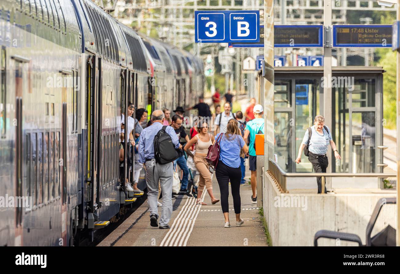 Reisende steigen aus der Zürcher S-Bahn Linie S9 (SBB Re 450) am Zürcher Bahnhof Hüntwangen-Wil aus.  (Hüntwangen, Schweiz, 17.07.2023) Stock Photo