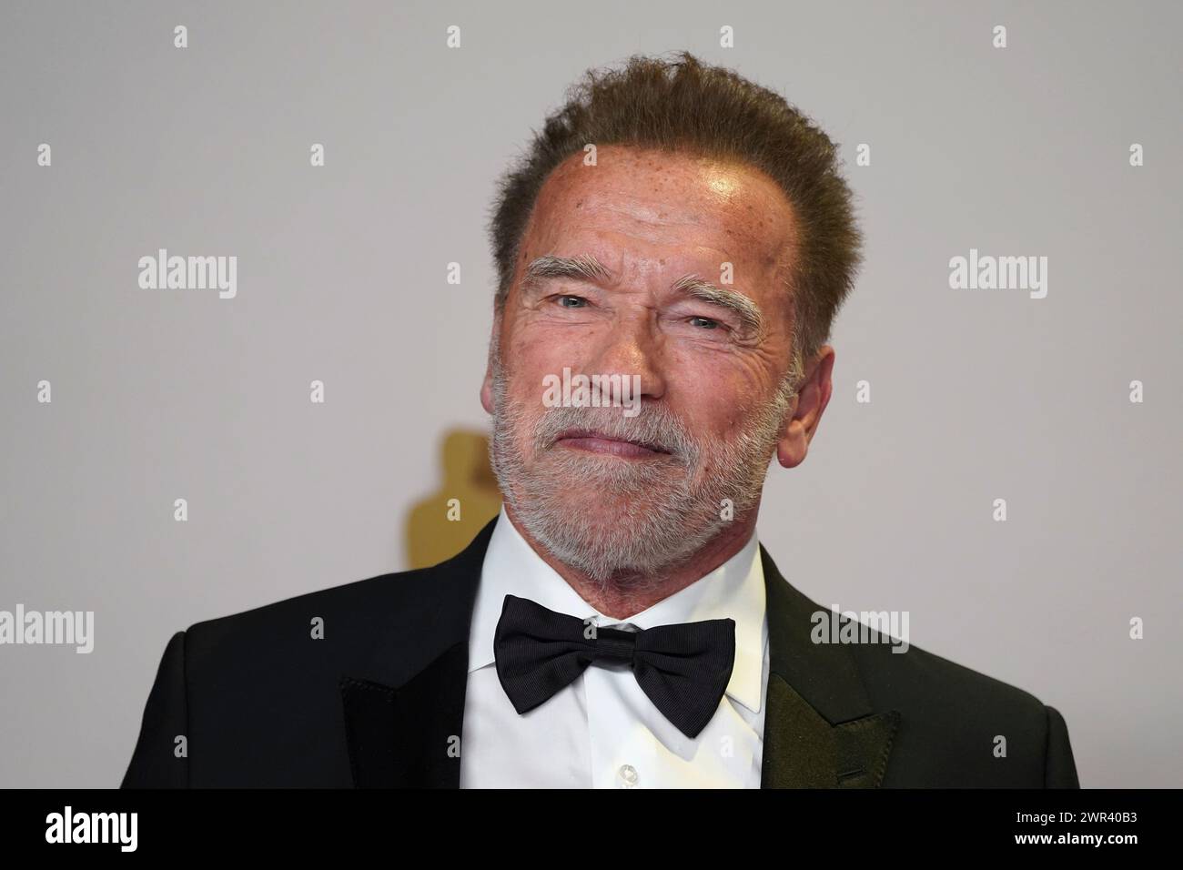 Arnold Schwarzenegger poses in the press room at the Oscars on Sunday