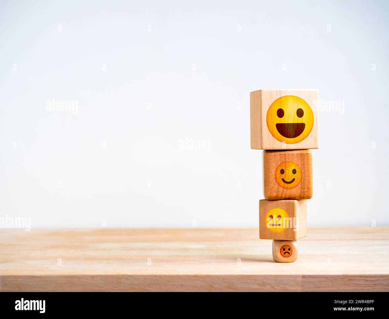 Customer service evaluation, marketing feedback, ratings, satisfaction survey, mental health and psychology concept. Wooden block stack with cute emot Stock Photo