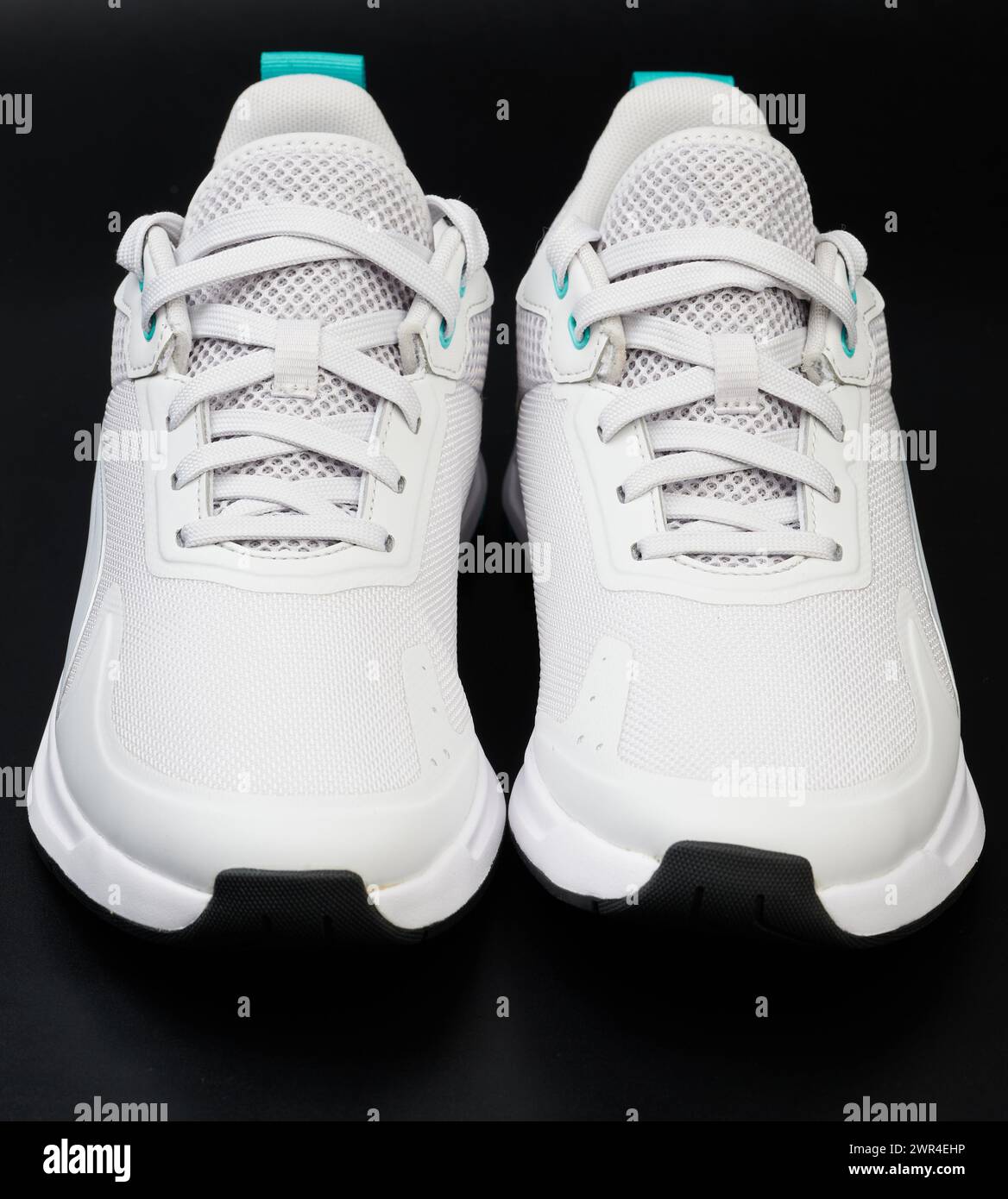 Clean new white pair of shoes front view isolated on black studio background Stock Photo