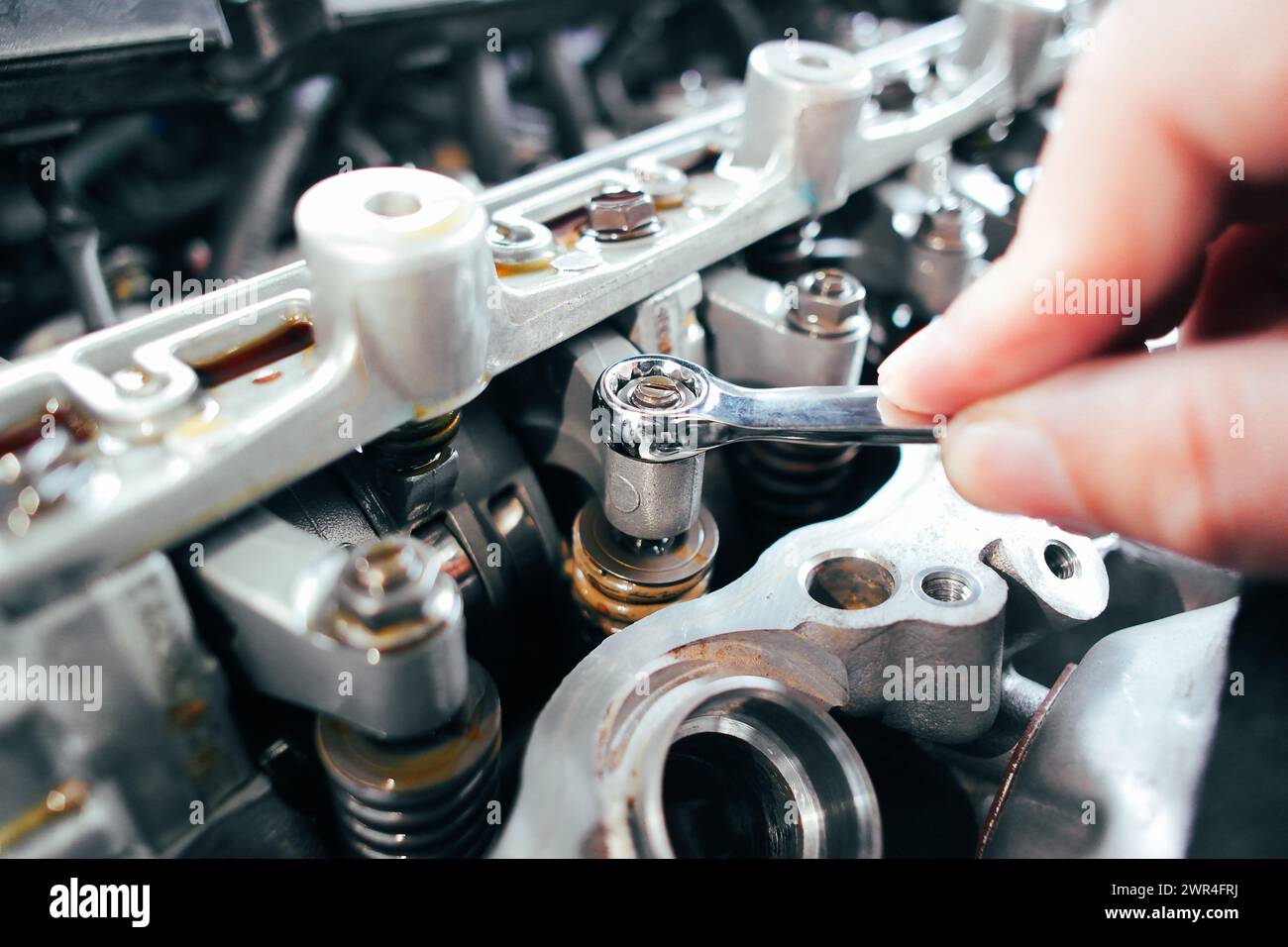 Car mechanic checking and adjusting valves of car engine, Car