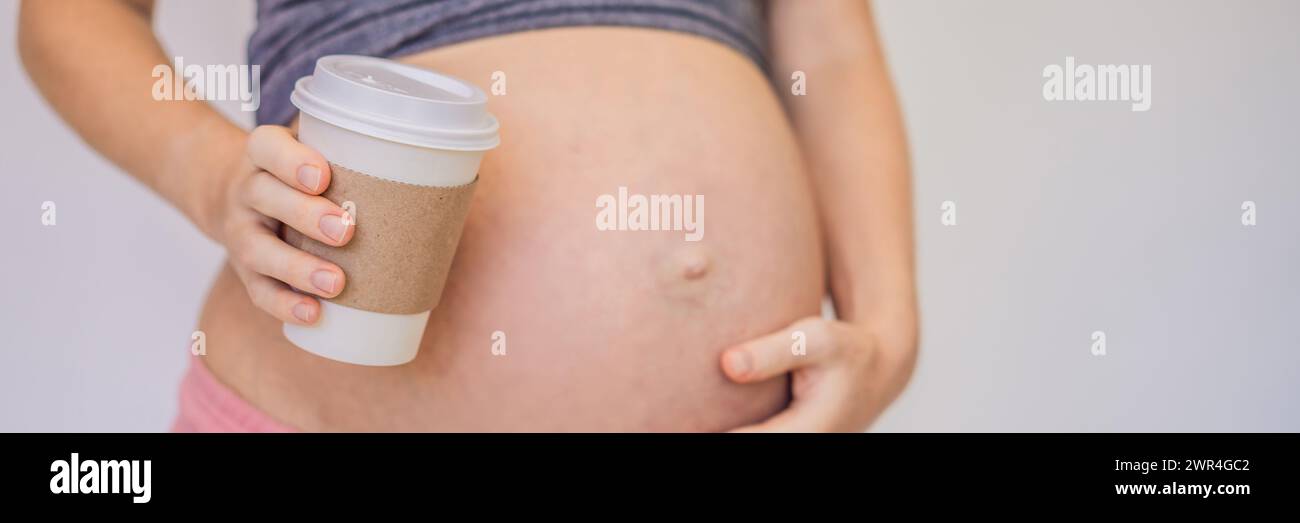 A pregnant woman holds a cup of coffee in her hands. Caffeine safety ...