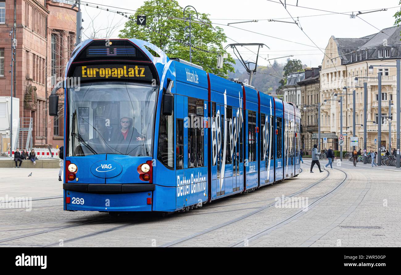 Eine Strassebahn der Linie 5 mit Ziel Europaplatz fährt beim Platz der alten Synagoge vorbei. Das Tram hat seitlich Werbung der BB Bank. (Freiburg im Stock Photo