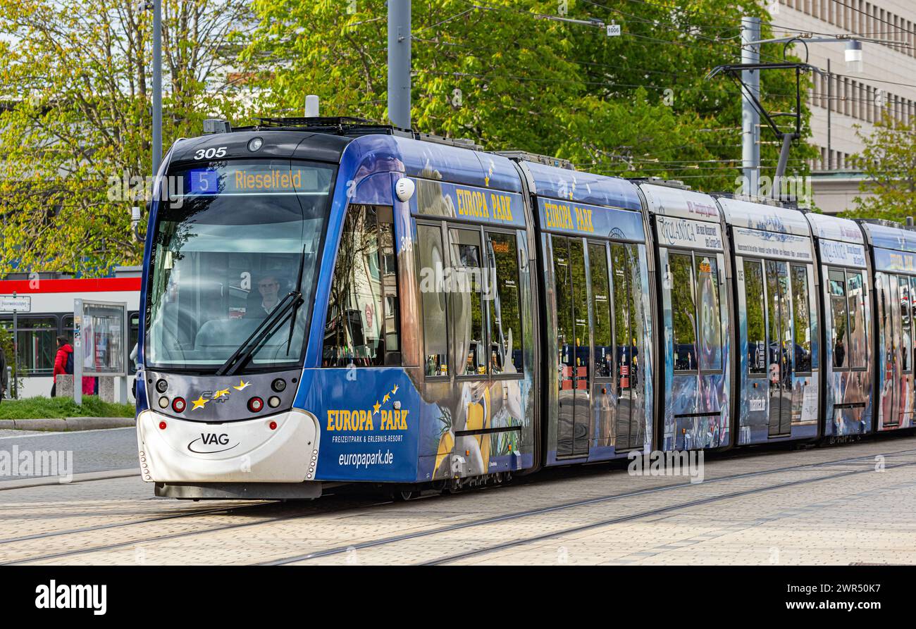 Eine Strassebahn der Linie 5 mit Ziel Risefeld fährt beim Platz der alten Synagoge vorbei. Das Tram hat seitlich Werbung des Europa Park in Rust. (Fre Stock Photo