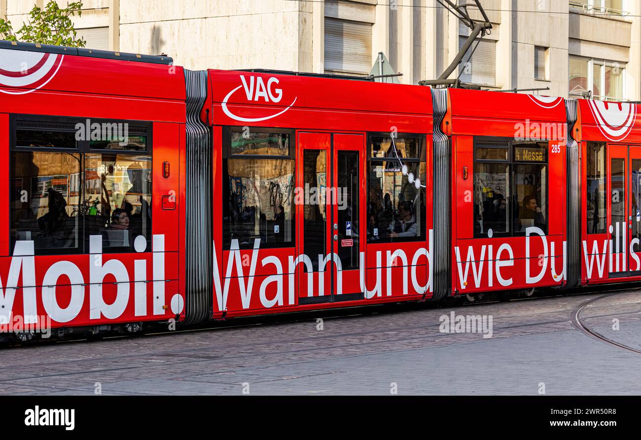 Eine Strassenbahn in Freiburg fährt am Platz der alten Synagoge vorbei. Auf der Seite sind verschiedene Mobilitätsformen zu finden. (Freiburg im Breis Stock Photo
