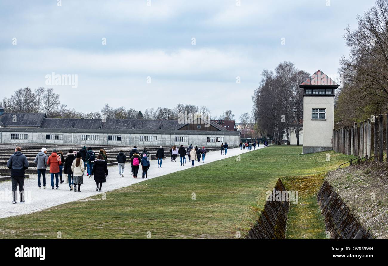 Blick entlang des Sicherheitszauns in Richtung Wachturm und Eingangsbereich. Für die Geschichte des Konzentrationslager Dachau interessieren sich zahl Stock Photo