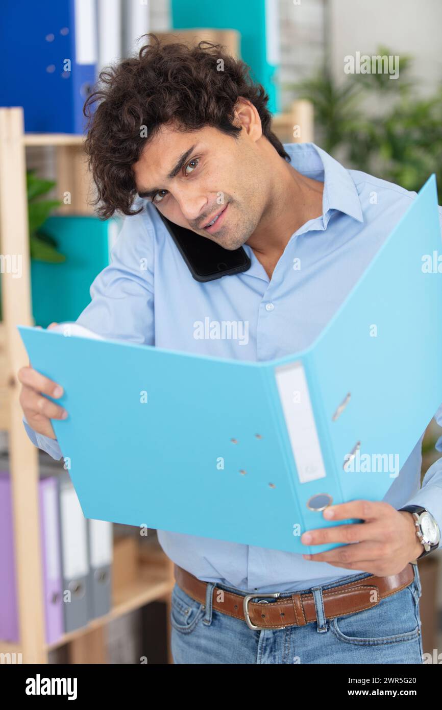 businessman holding document and speaking on phone Stock Photo