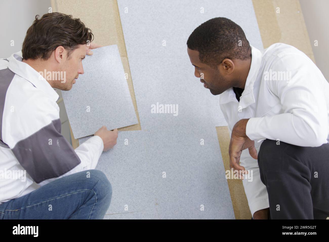 two workers checking something on the wall Stock Photo