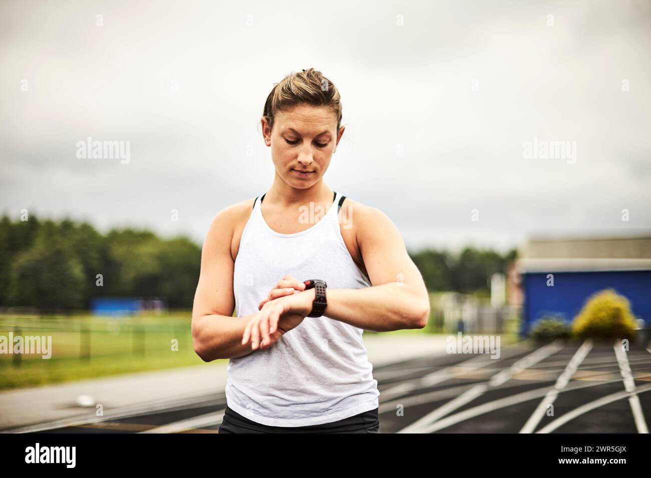 Female runner checking fitness tracker watch, Lincoln, Massachusetts, USA Stock Photo