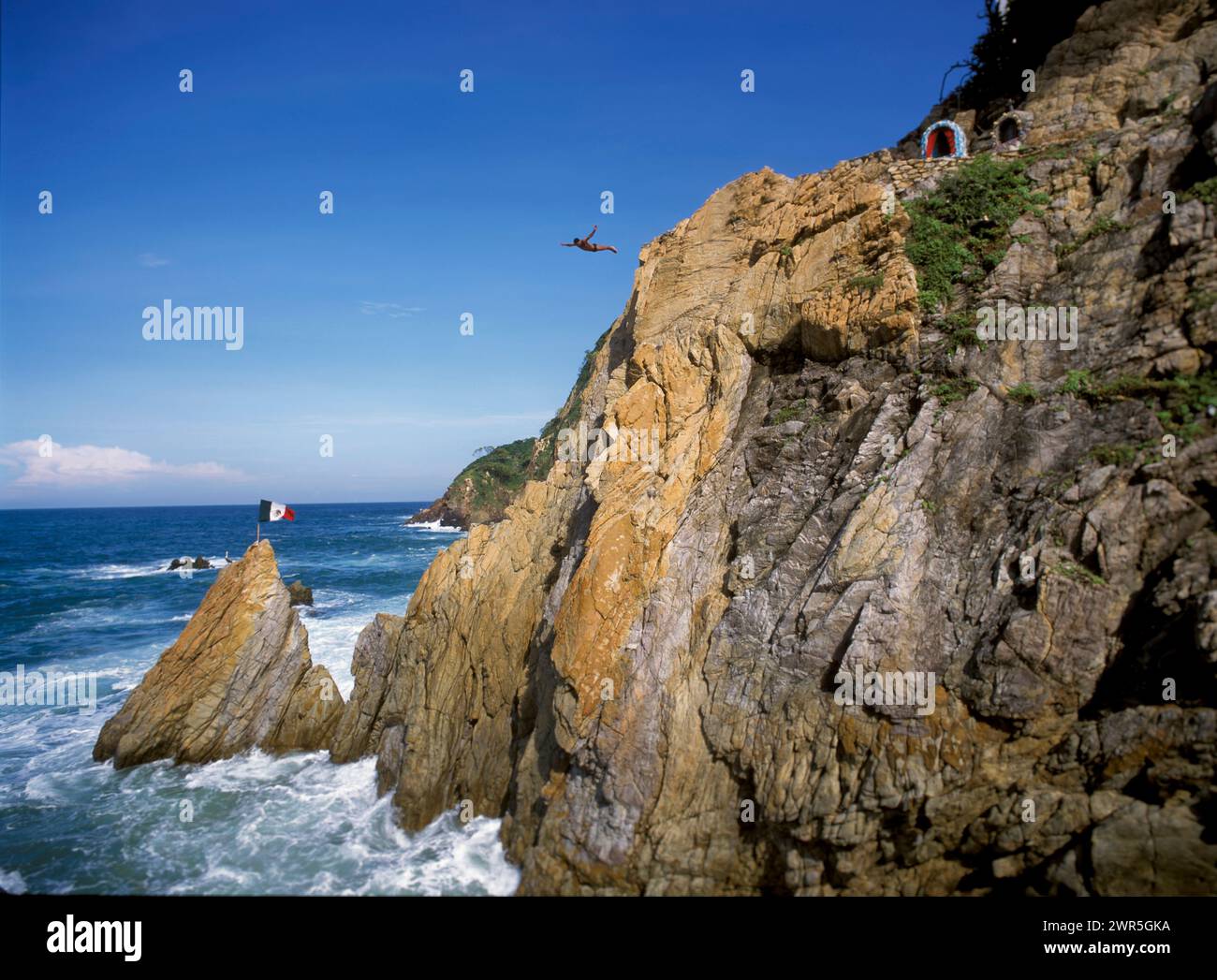 Mexico: Acapulco: A La Quebrada cliff diver leaps into the Pacific Ocean, along the Mexican Riviera Stock Photo