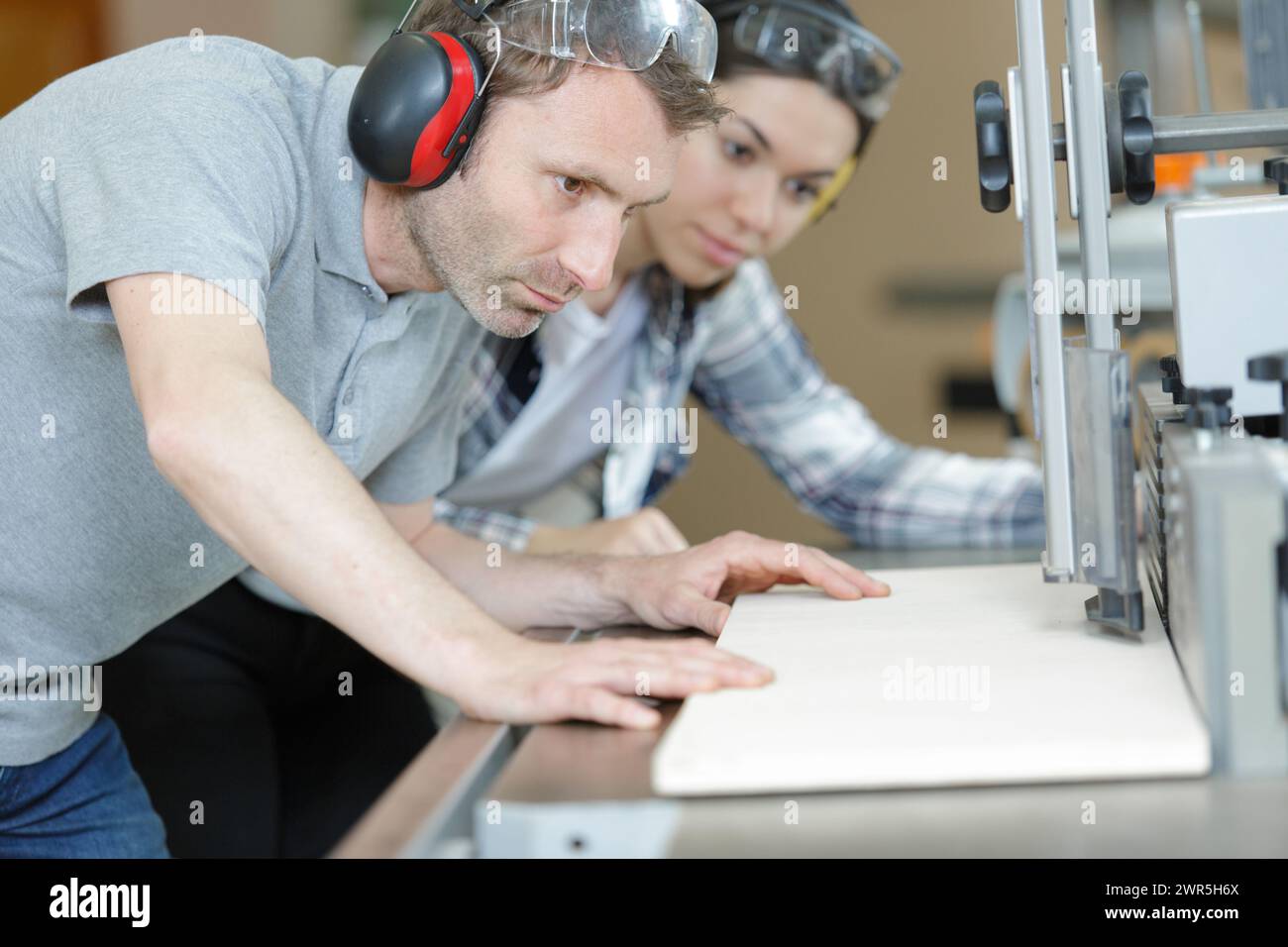two carpenters making holes in wood plank Stock Photo
