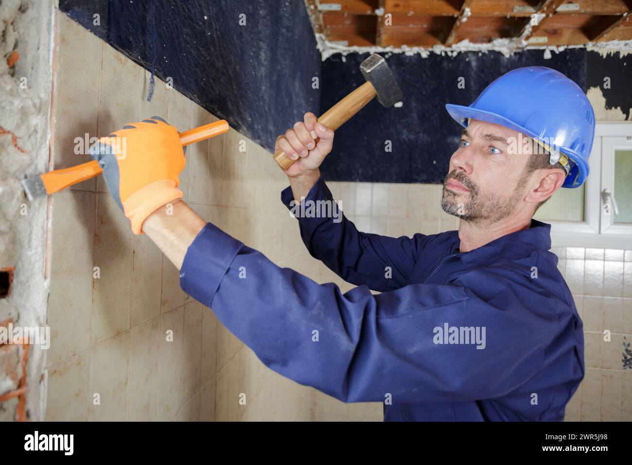 constructon worker using a hammer and chisel Stock Photo - Alamy