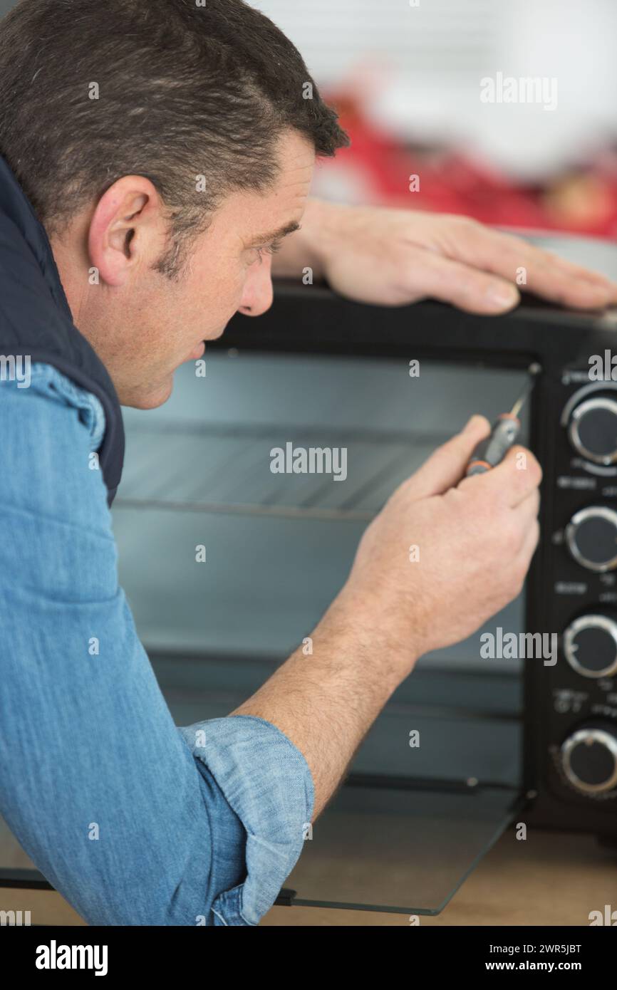 male worker fixing an oven Stock Photo Alamy