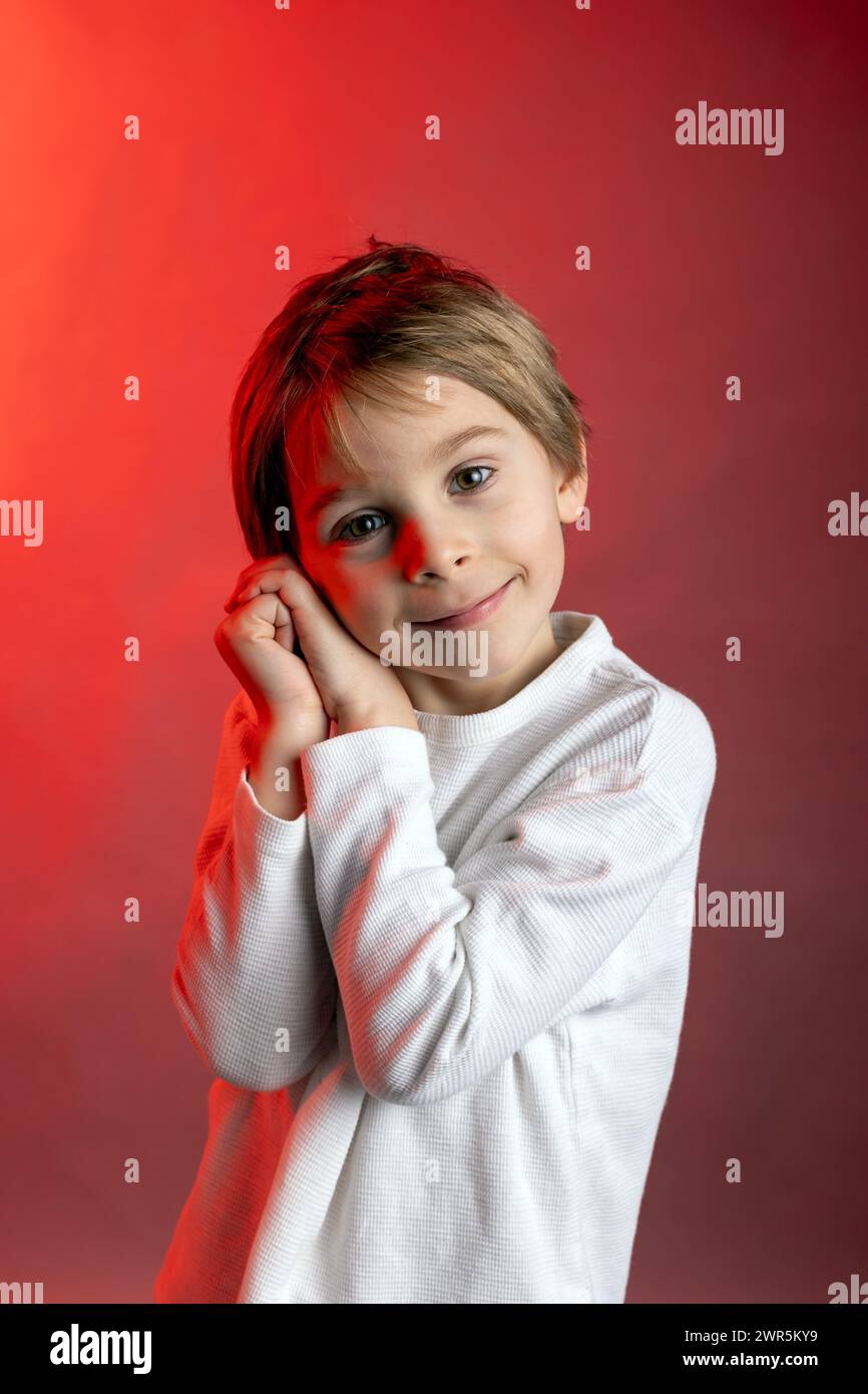 Artistic portrait of a child, boy, lightened with gel filters, studio shot with colors Stock Photo