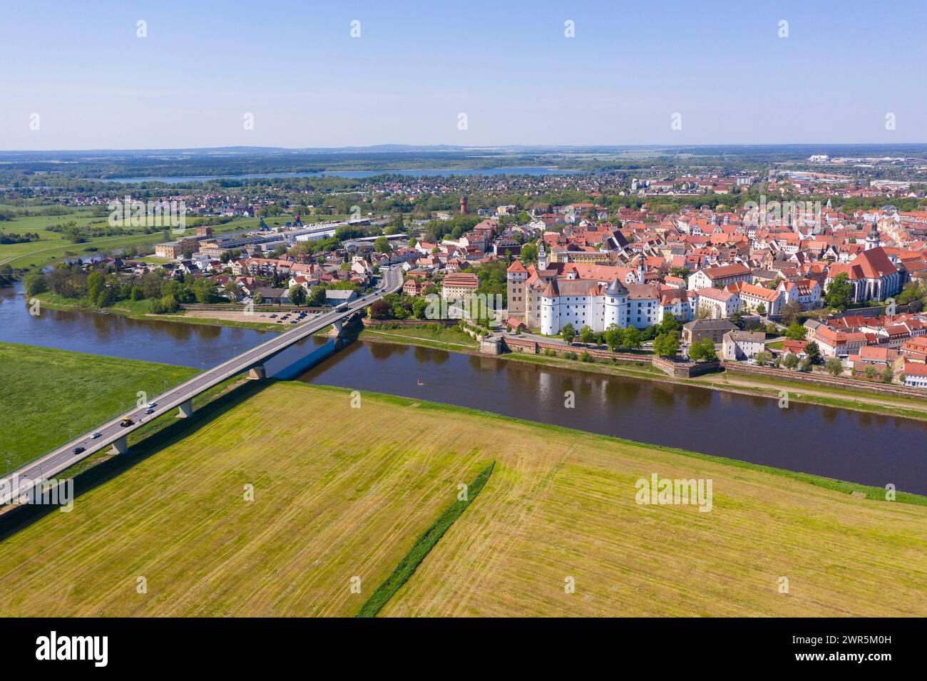 Luftbild mit Elbe, Elbbrücke, Schloss Hartenfels und Altstadt,