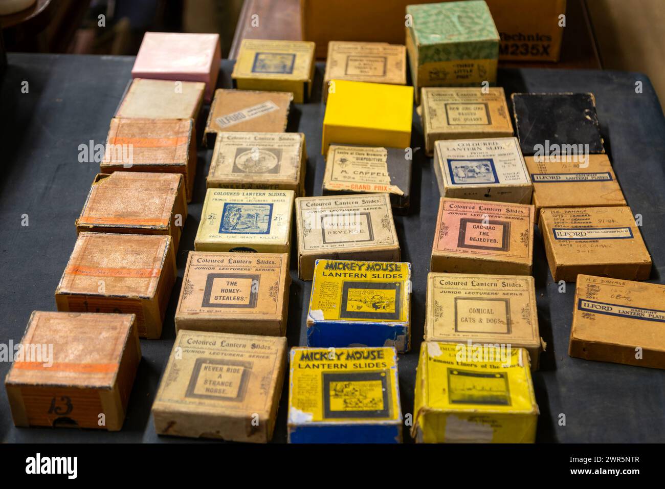 Boxes of commercial magic lantern slides on table top display, UK Stock Photo