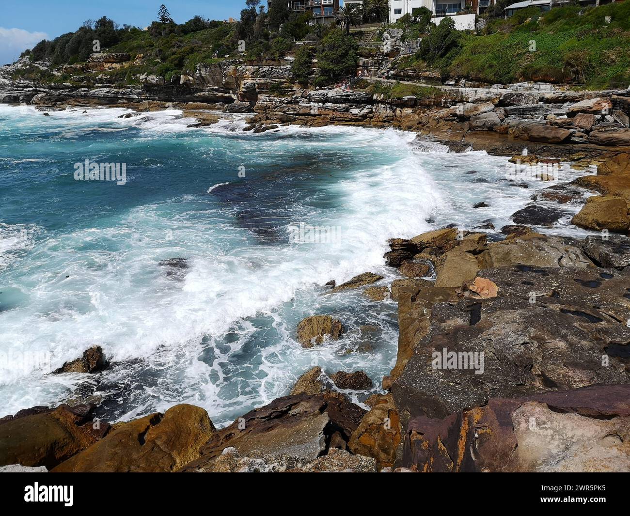 The rocky shoreline with serene waves. Bondi walk to Coogee, Australia Stock Photo