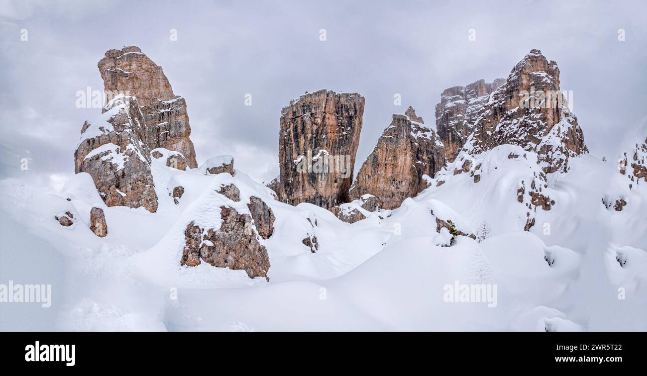 This winter snowy image is of the Cinque Torri, five towers, mountain group of giant sized erratic type Dolomite mountain boulders located near the famed alpine resort town of Cortina d' Ampezzo, in the Italian Province of Belluno Stock Photo