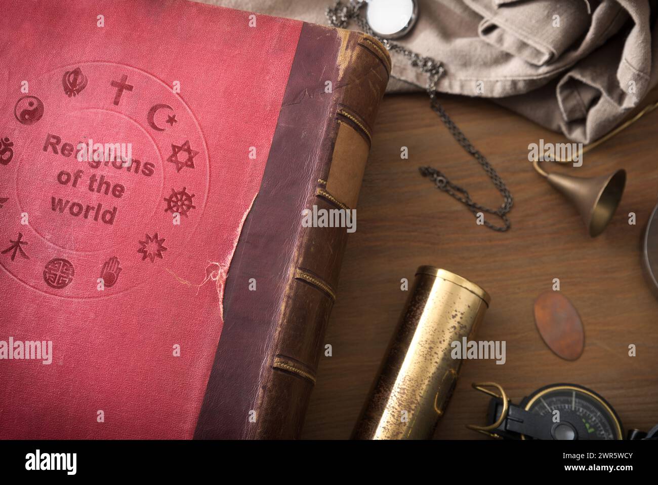 Detail of old book of the study of religions in the world wooden table with decorative objects. Top view. Stock Photo