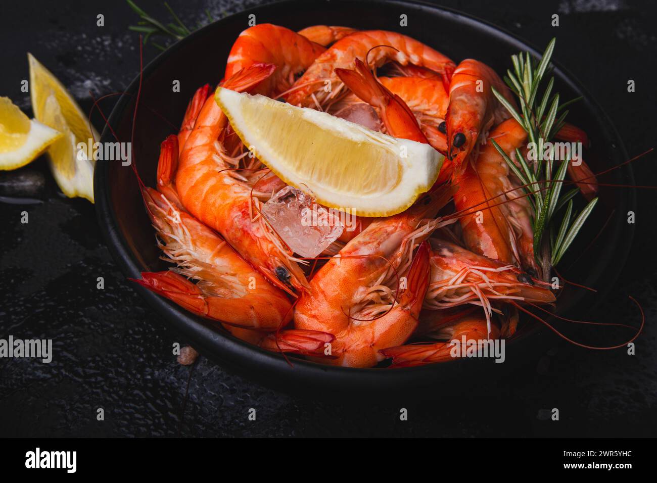 Appetizing prawns with lemon and herbs, presented for gourmet recipes or healthy eating guides. Stock Photo