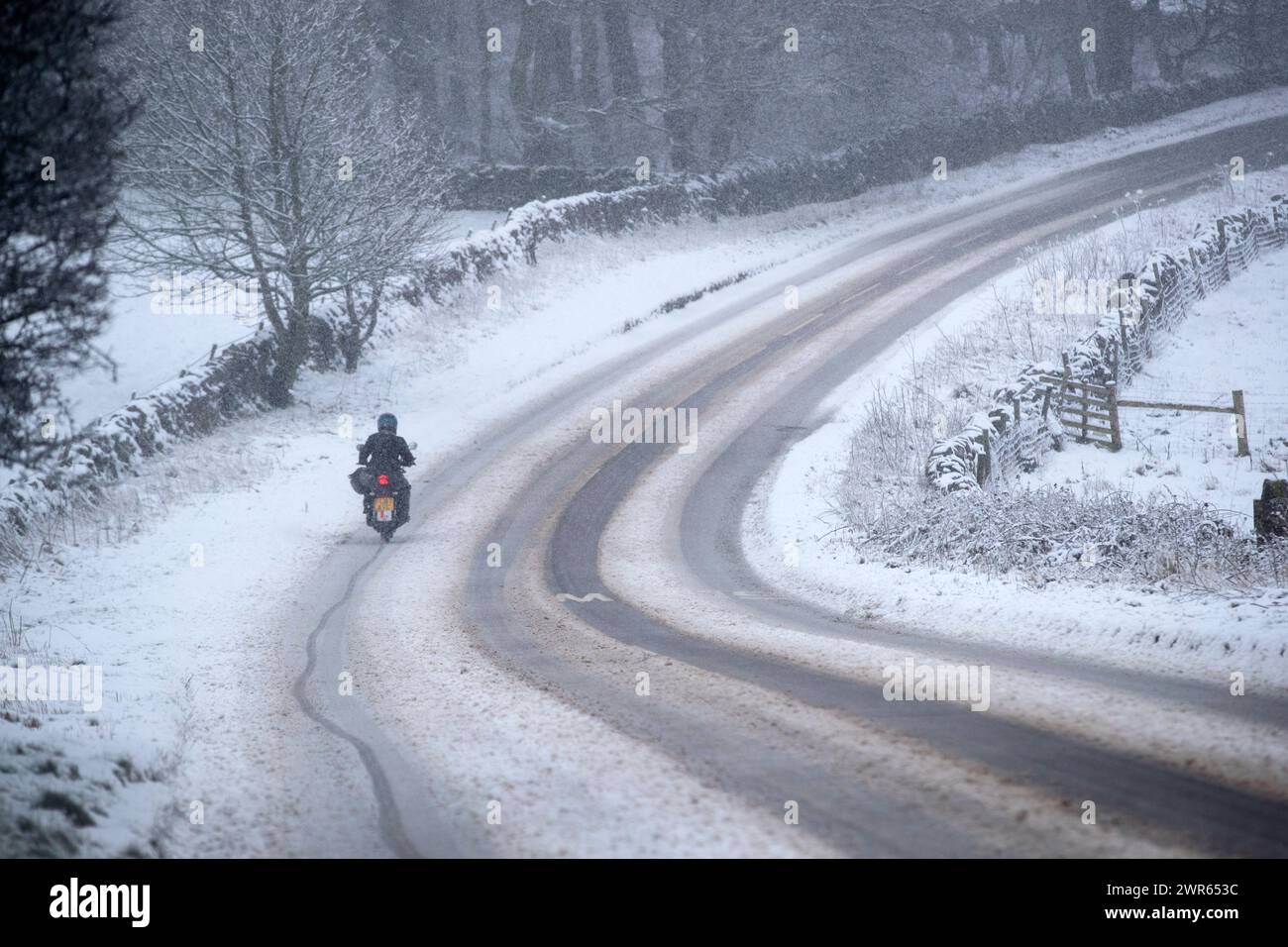 29/01/19  A young lady motorcyclist slithers along a lane near Mensal Head, Bakewell, Derbyshire. She had already crashed and smashed up her bike but Stock Photo