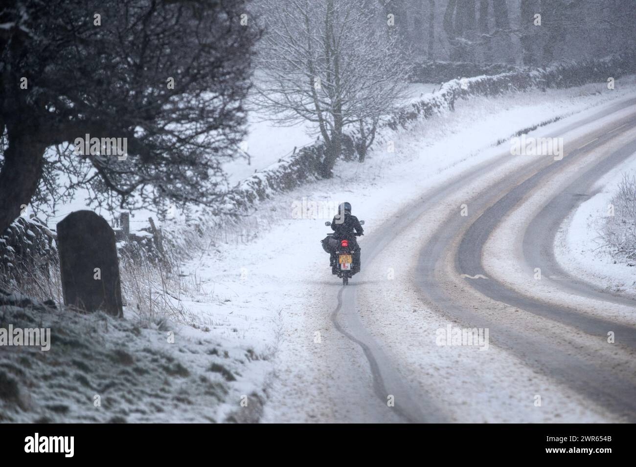 29/01/19  A young lady motorcyclist slithers along a lane near Mensal Head, Bakewell, Derbyshire. She had already crashed and smashed up her bike but Stock Photo